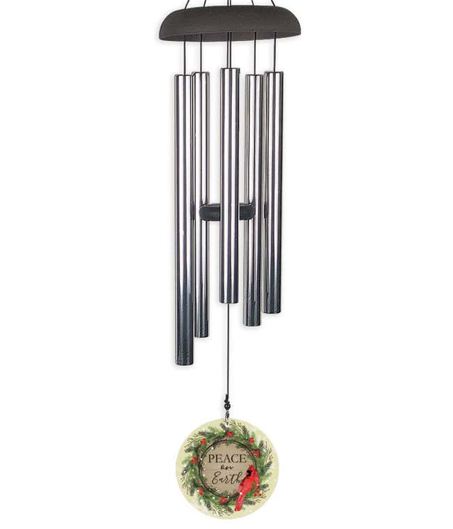 Wind chime with a sail that reads Peace on Earth, encircled by a wreath and a red caridnal.
